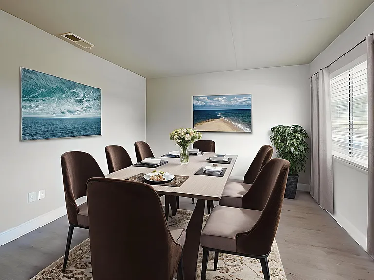 Elegant dining room with contemporary decor, featuring a stylish table set for eight, captivating ocean-themed wall art, and natural light streaming through large windows.