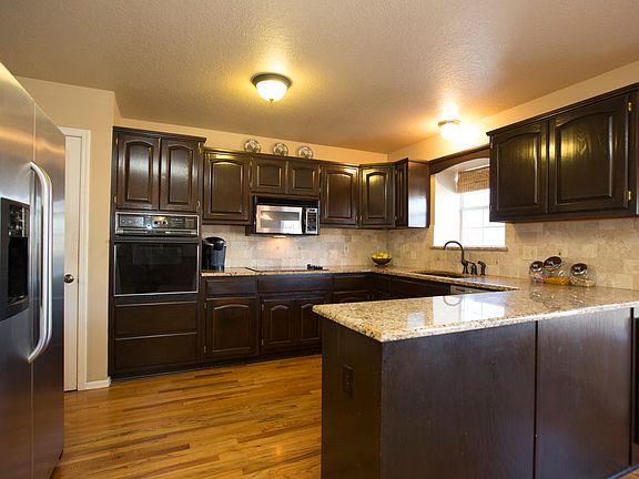 Gorgeous granite Kitchen features new oil rubbed bronze faucet, tumbled marble back splash, rich hardwood floors and full pantry.