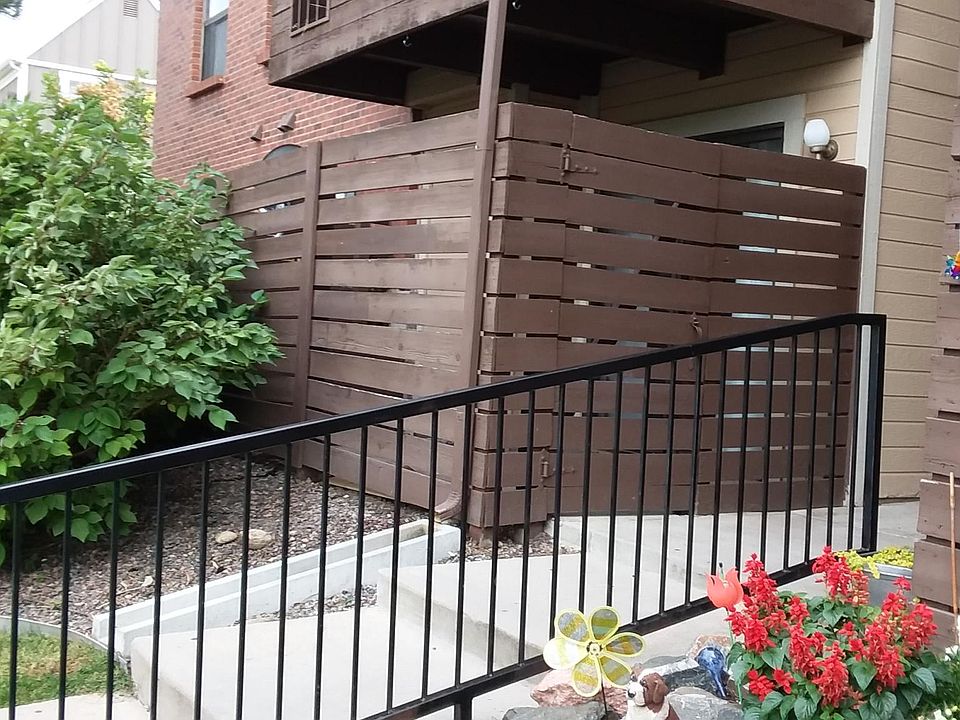 Condo entryway with gated enclosed patio. Patio has storage closet.