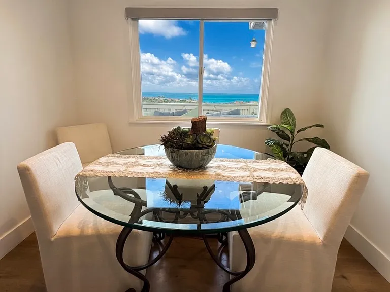 Enjoy meals with this breathtaking ocean view from elegant glass dining table.