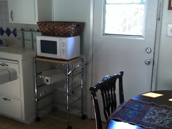 Partial view of kitchen and back door to outdoor fenced yard