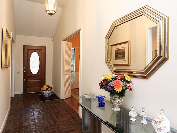 FOYER-spacious with vaulted ceiling pendant lantern and charming brick flooring.  The living room is to the right and dining to the left.