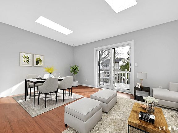 Large, open living area lets in plenty of light with two skylights and a sliding door that leads out to the deck.
