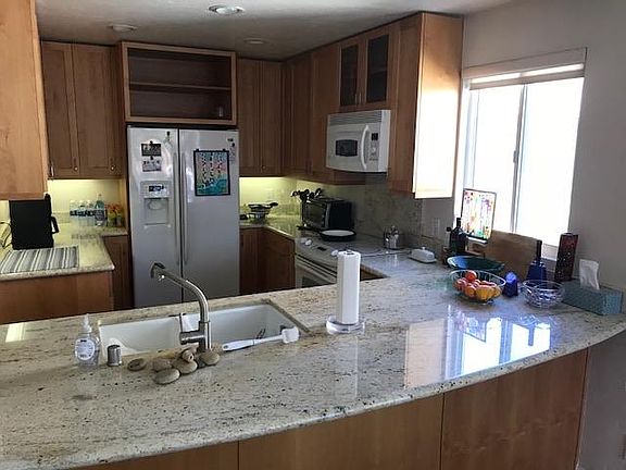 Kitchen with fridge, microwave, stove, oven and eating bar