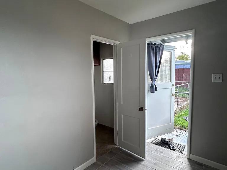 Bedroom - Door on the left is access to the bathroom. Door on the right leads to the backyard
