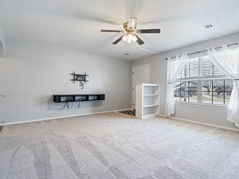 Living Room and front door. Built in shelves. Entertainment center and mount for TV on the left