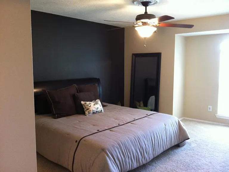 Primary bedroom with bump out southern exposure double window. Remote ceiling fan/light.