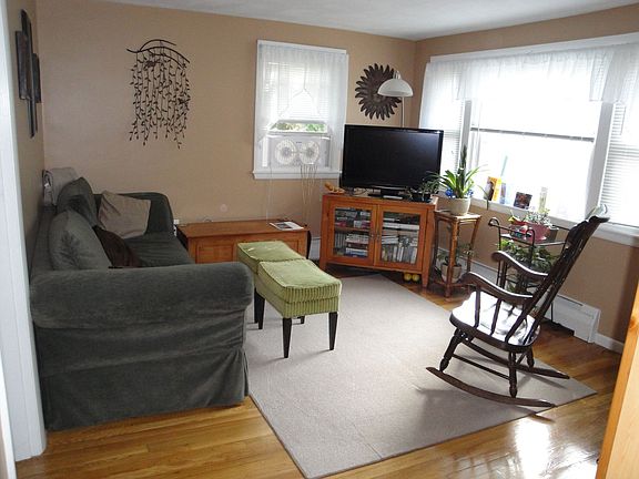 Sunsplashed living room with bay windows and refinished hardwood flrs.