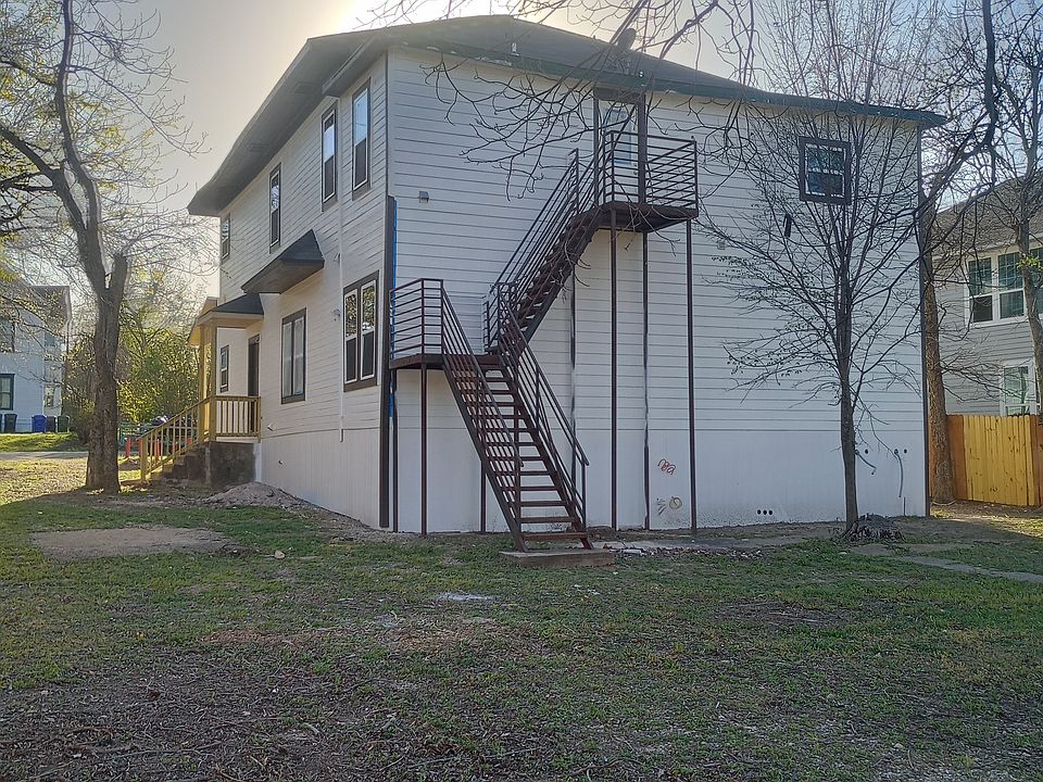 Wider shot from the fenced around backyard with mature trees.