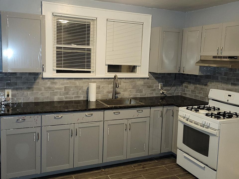 brand new grey flooring, new light grey cabinets, new granite countertop, new back splash