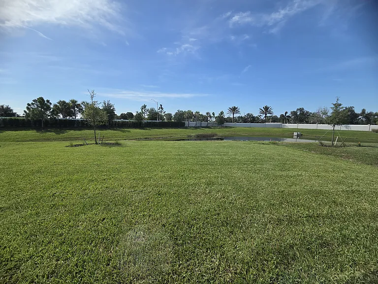 Large backyard with a pond view