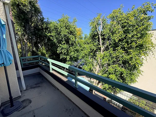 Balcony has a view of large shade trees