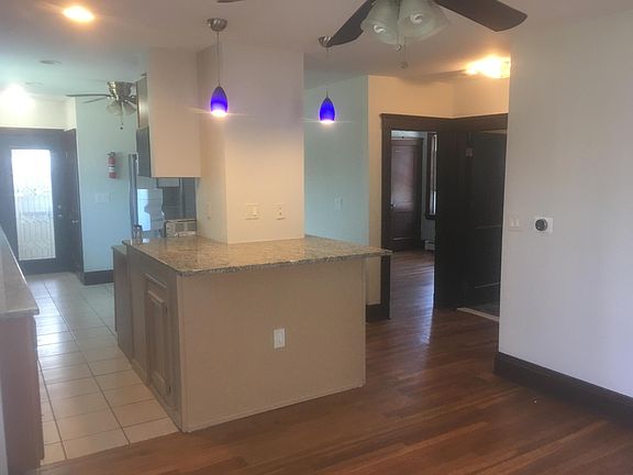 Kitchen view with overhanging granite counter island, freshly painted.