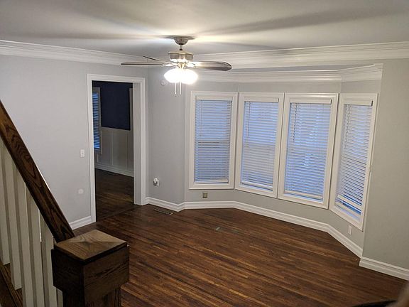 Living room with natural lighting, ceiling fan, hardwood floors, window blinds. Room size: 15' x 15'