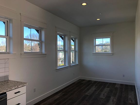 LIving space off the kitchen with lots of windows and high ceilings throughout.