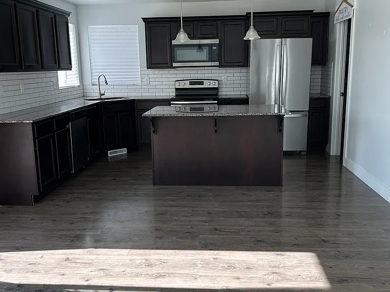 Kitchen with marble counters and brown cabinets and large pantry