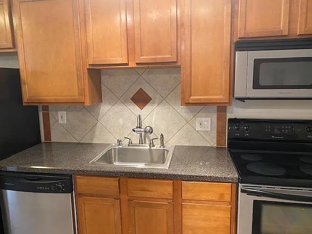 Kitchen with dish washer, microwave, and oven.
