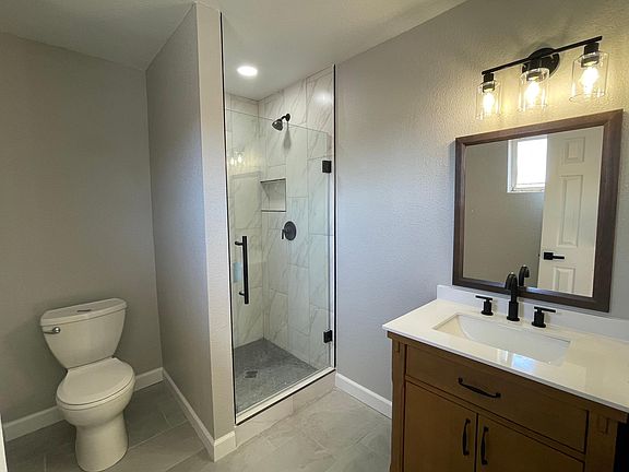 Master bathroom with walk-in shower, oak vanity and brand new toilet.