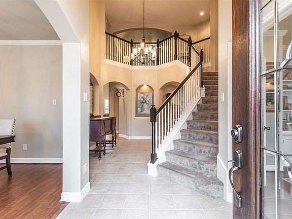 Enter through the leaded glass front door on tile flooring with two story ceilings over head.