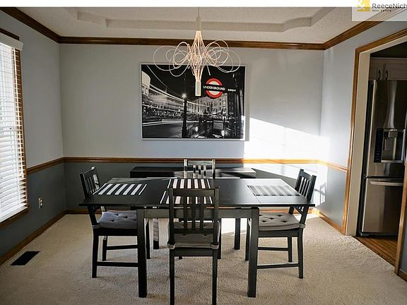 Updated dining room with modern light fixture, sculpted tray ceiling.