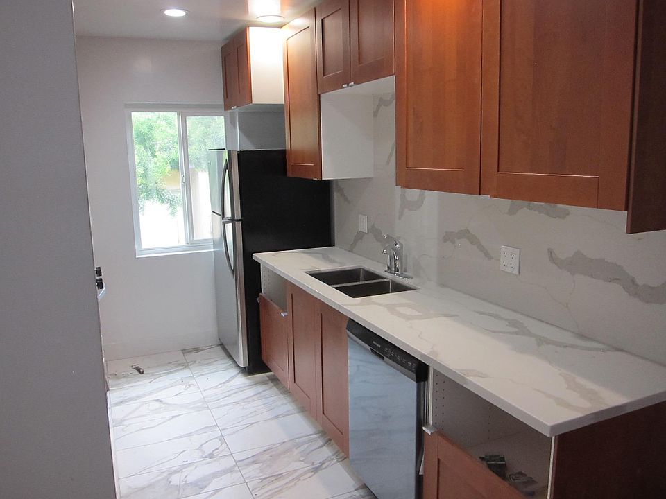 Brand new kitchen with stainless steel appliances and marble