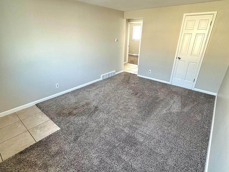 Bright and inviting room with fresh carpet, neutral toned walls, and a modern light fixture, perfect for a cozy living space.