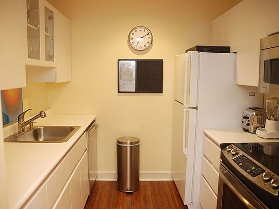 Galley kitchen with stainless steel appliances and bamboo flooring