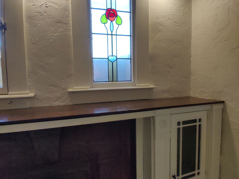 living room stained glass window and antique fireplace