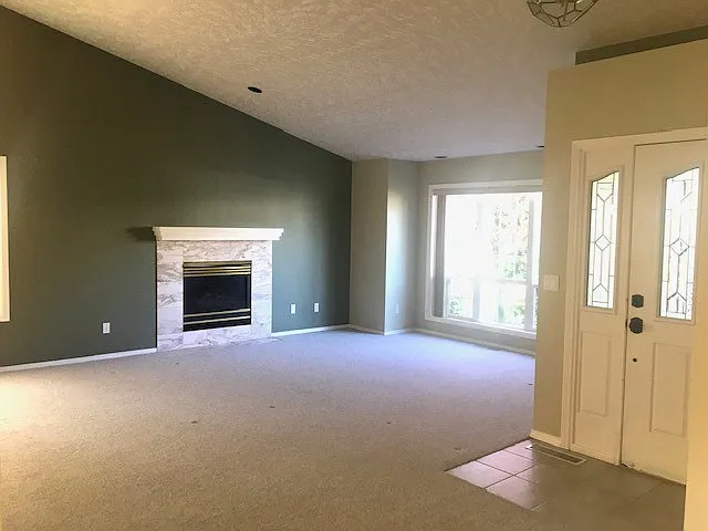 Spacious formal living room with gas fireplace and vaulted ceilings.