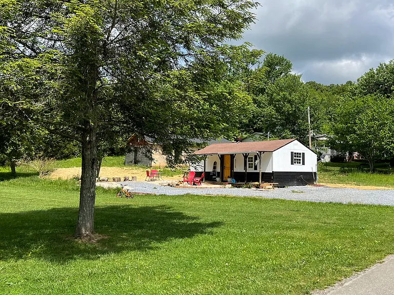 There are two houses on the property. The yard space belonging to the front house is behind the house.