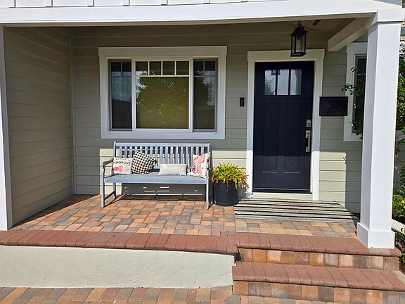 Welcoming front porch with Ring doorbell security system, pavers, bench seating, and double-pane windows for energy efficiency.