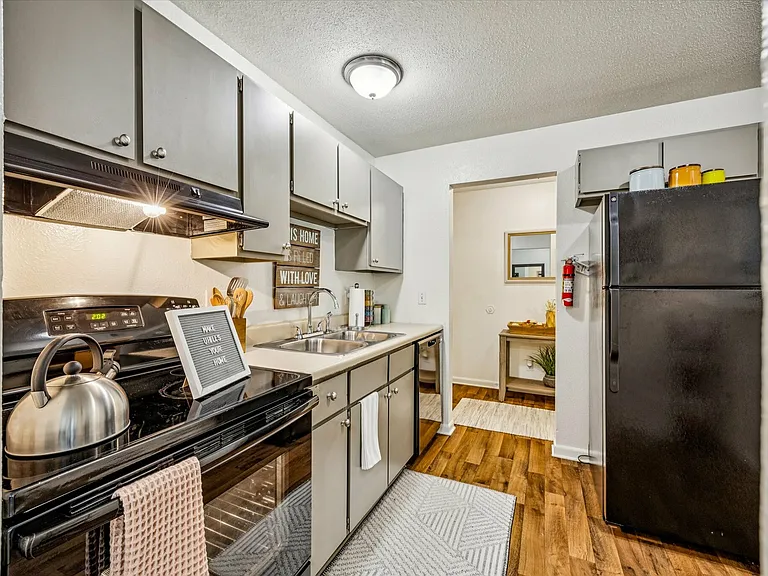 Cook and dine in style with modern black appliances and sleek cabinetry at University Hills Apartments near the University of Toledo.