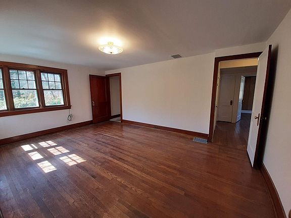 Large bright living room with hardwood floors and wood panel doors