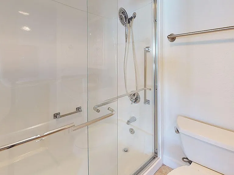 Elegant bathroom with modern glass shower enclosure and pristine white fixtures.