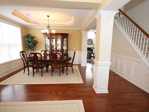 The formal dining room also boasts paneling, crown molding, and hardwoods.