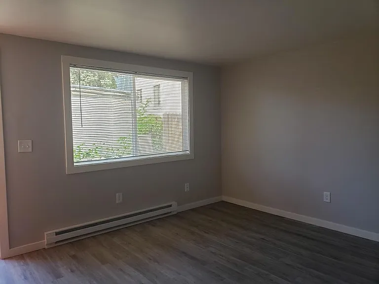 Living room, large window provides natural lighting and airflow. New blinds in living room and bedroom.
