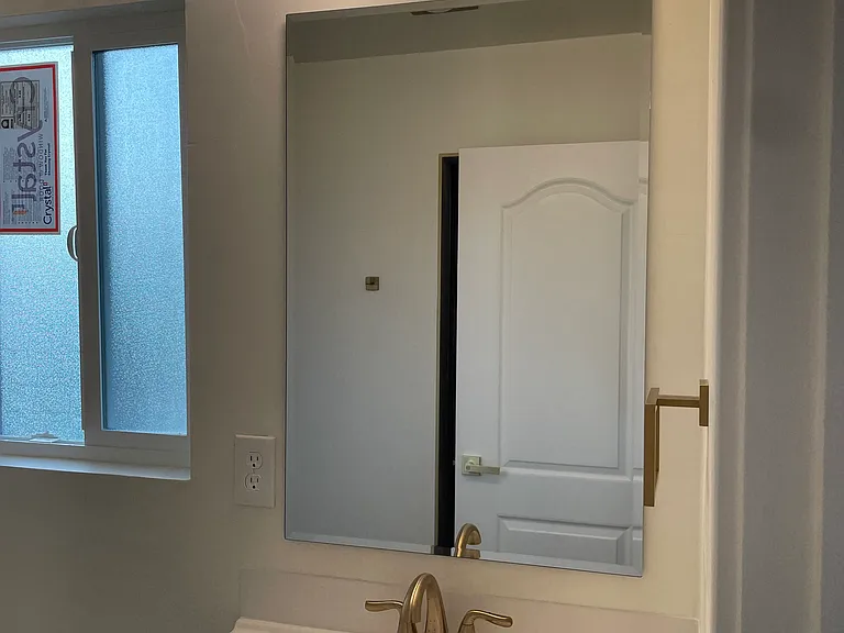 Bathroom-2 custom-designed vanities, Delta gold hardware, large-format tile, and modern rainfall showers