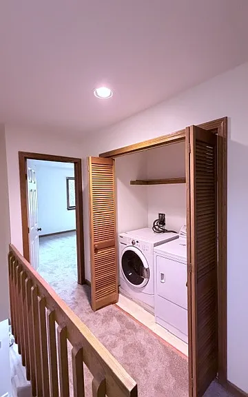 Laundry room is upstairs in the hallway between bedrooms