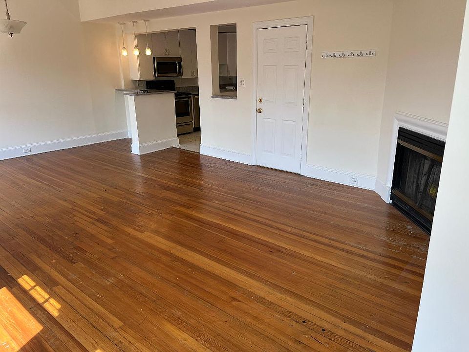 Living room/dining area as you walk in. Fireplace to the bottom right. Kitchen with high top counter towards the top of picture.