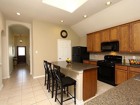 Open kitchen with island. Granite counter tops with tile back splash. Natural skylight.