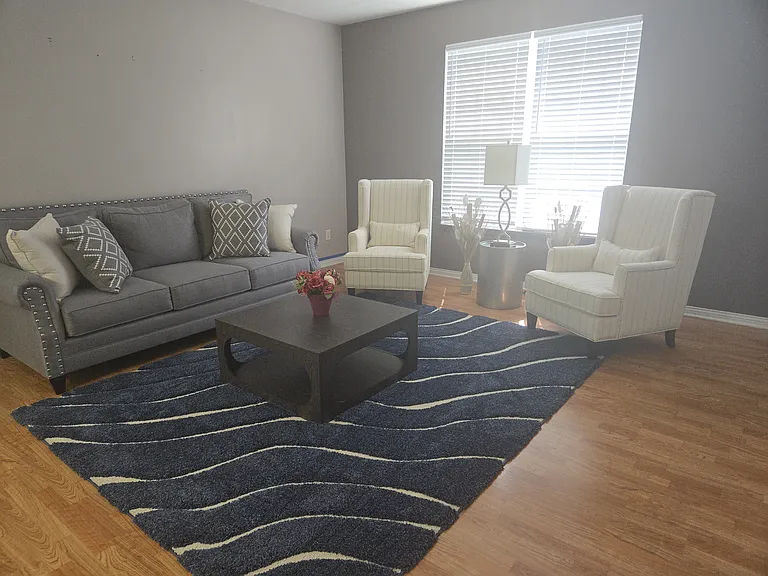 Furnished living room: Couch, (2)Chairs, area rug, coffee table, end table, and lamp