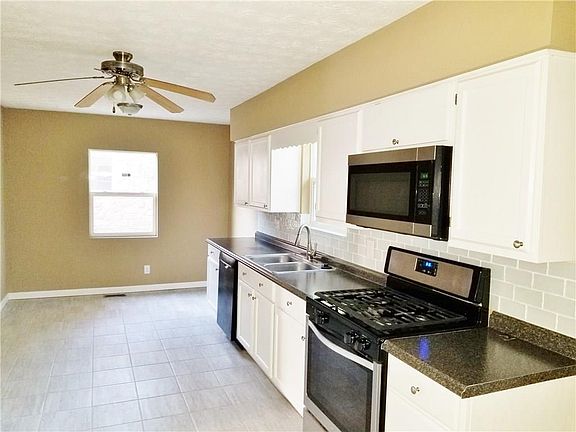Bright kitchen with stainless/black appliances...new counter top...look how much natural light!!