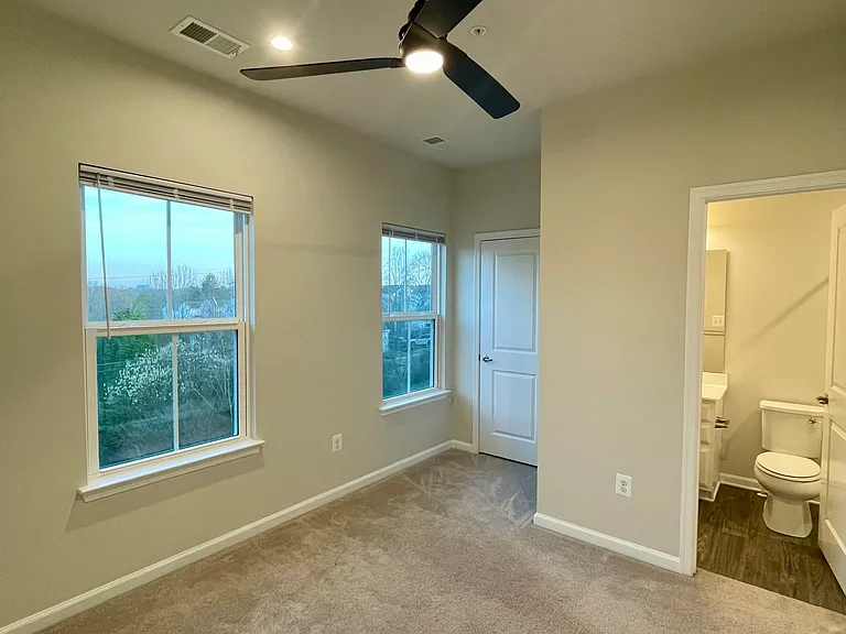 Front facing bedroom or office with private bathroom, natural light, and ceiling fan