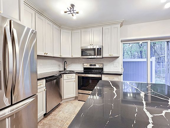 Brand-new kitchen with new stainless steel appliances, large island and quartz counter tops. Dining area features a sliding door to the private patio.