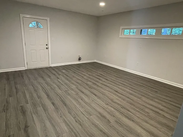 A spacious living room! This interior view shows the front door to the apartment along with the large open living room area.