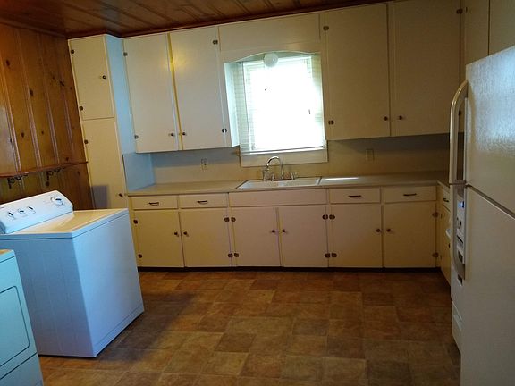 Kitchen with lots of cabinets, range, refrigerator, washer and dryer