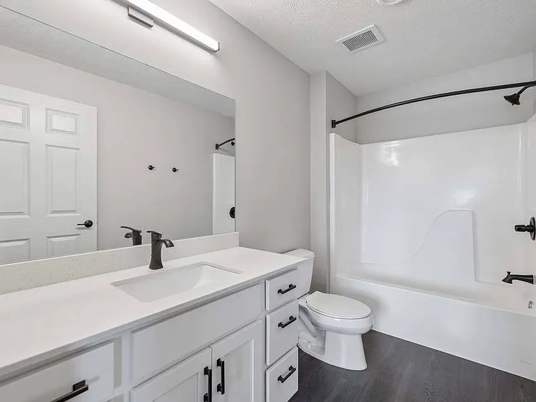 Bright finishes, contemporary fixtures, and a spacious layout create a bathroom that feels both polished and refreshingly comfortable.