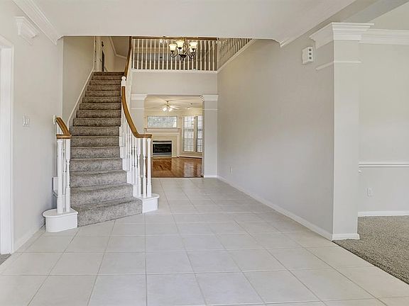 Inviting tile floor entry with elegant staircase and landing.