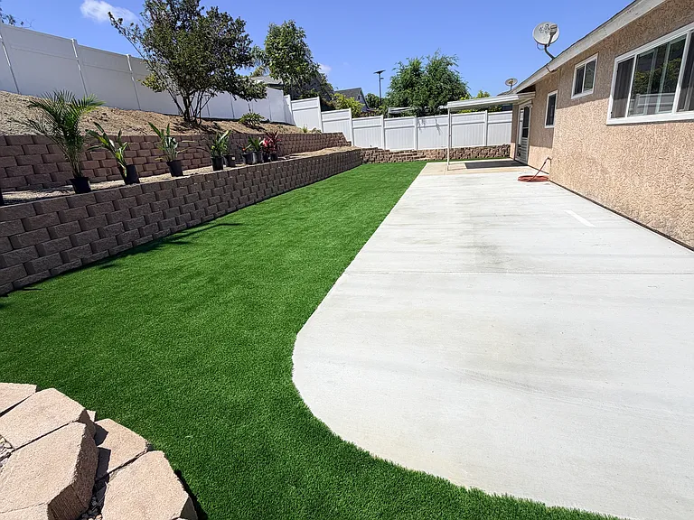 Newly renovated backyard. Artificial turf, planting area top terrace. Secondary lounging area middle terrace.