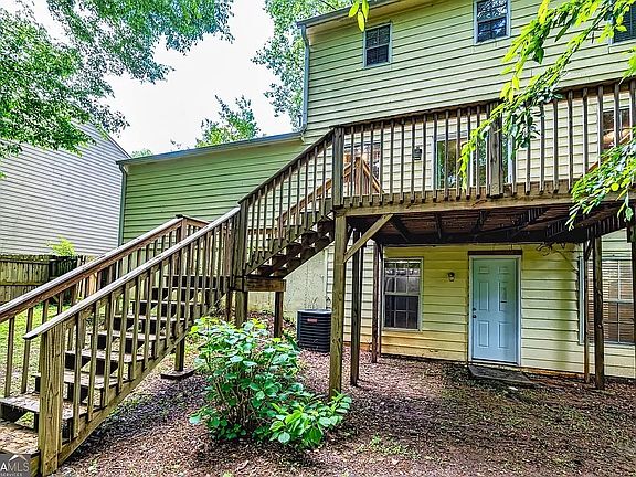 Exterior back view of home showing a large wood deck and the partially finished walkout basement.